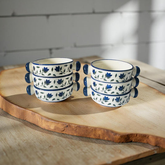 Set of ceramic cups with blue floral patterns on a wooden surface