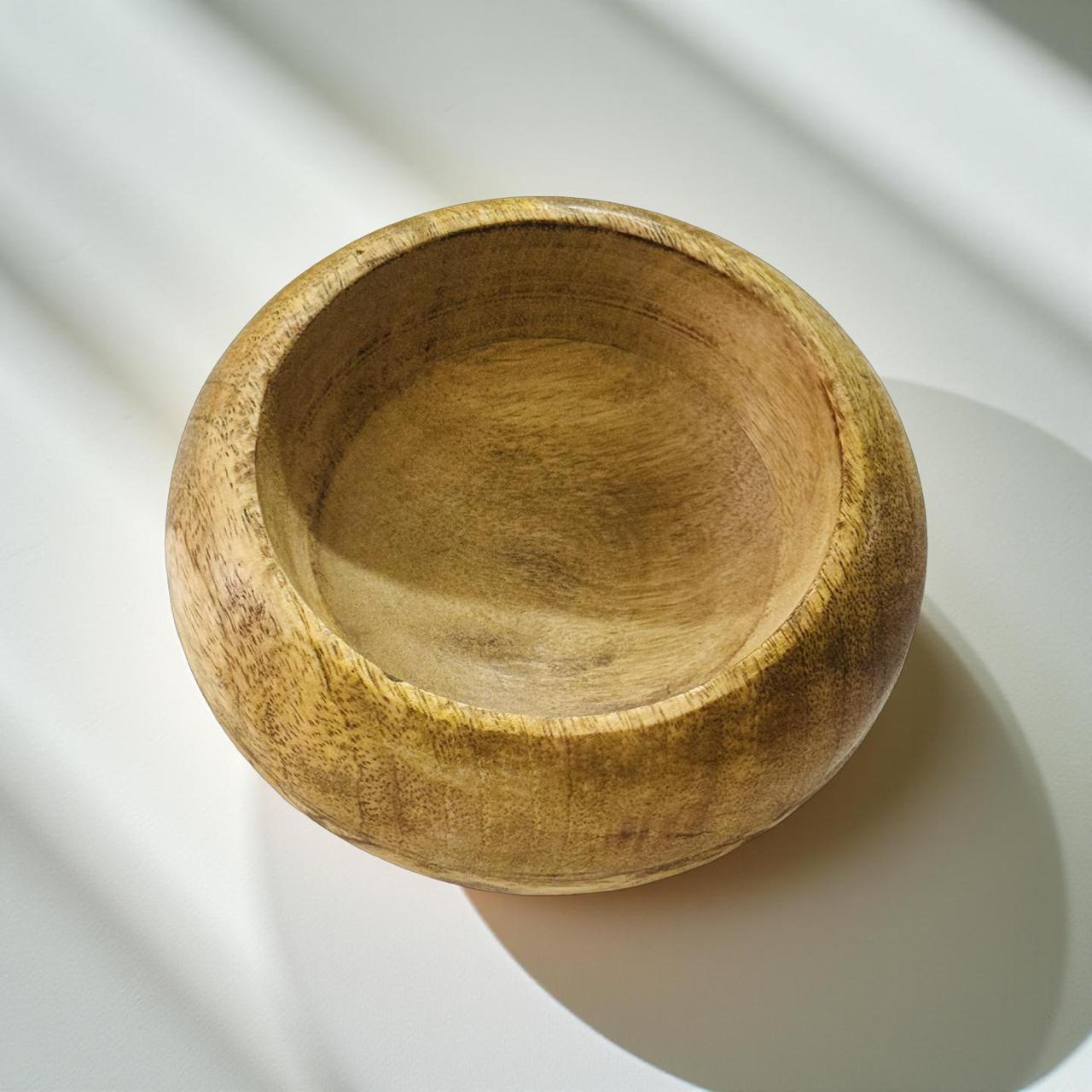 Wooden bowl on a white surface with soft shadows