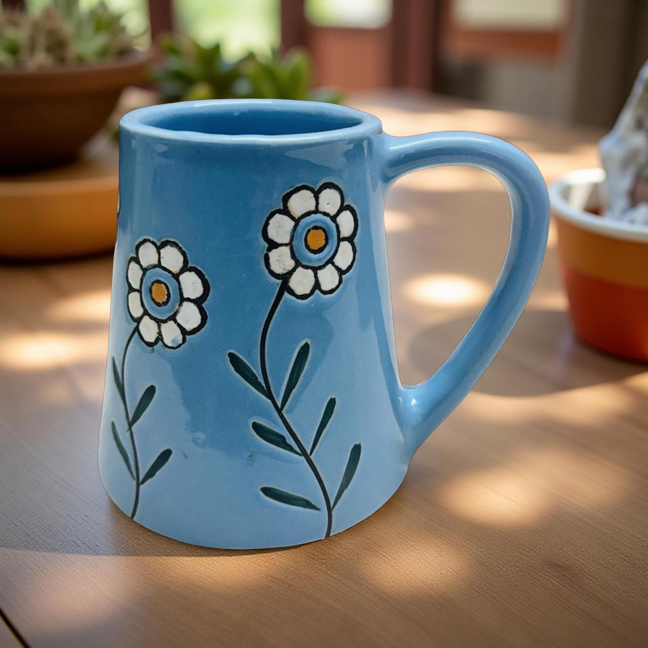 Blue mug with floral designs on a wooden surface