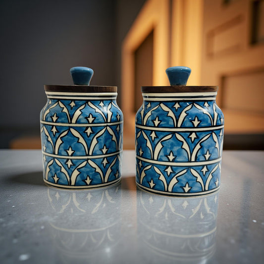 Set of two blue Moroccan pattern ceramic jars with wooden lids placed on a soft beige cloth