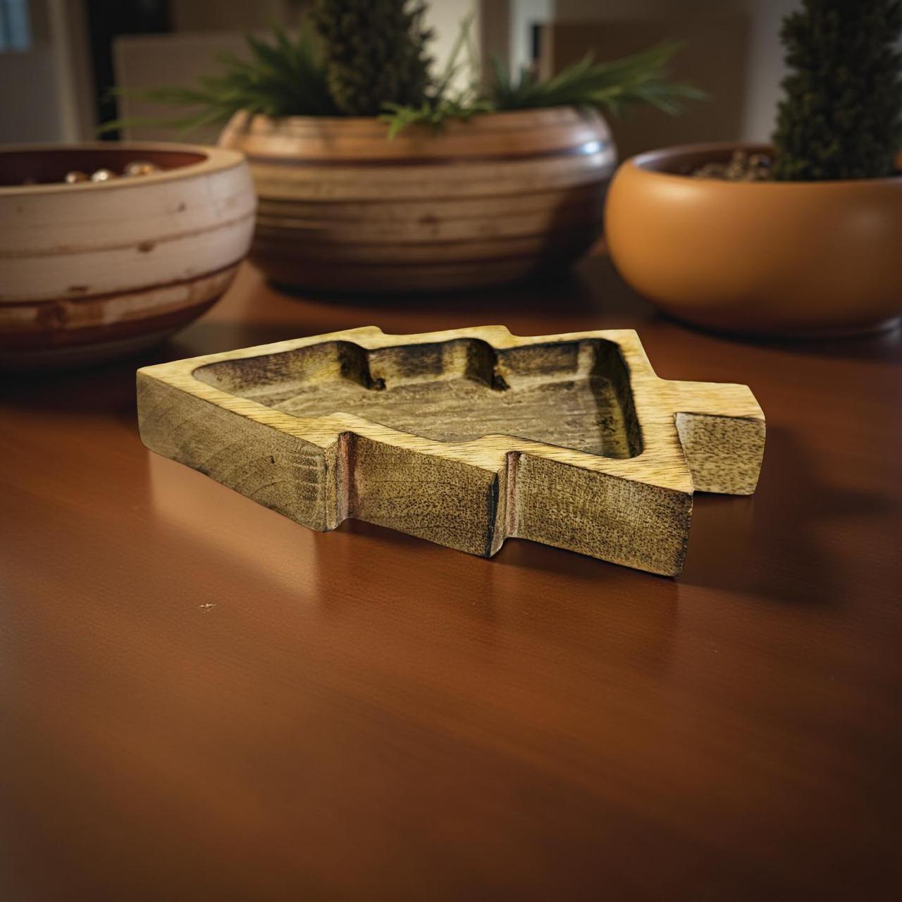 Wooden DIY candle holder on a wooden surface with blurred plant pots in the background