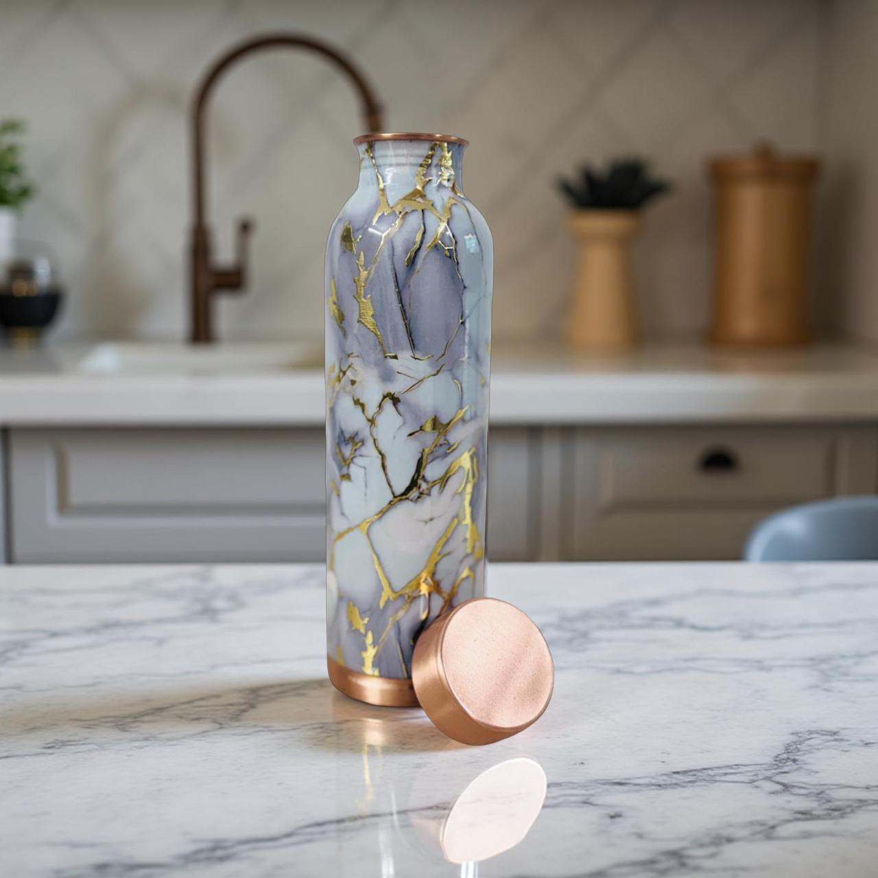 Marble-patterned water bottle with rose gold accents on a kitchen counter