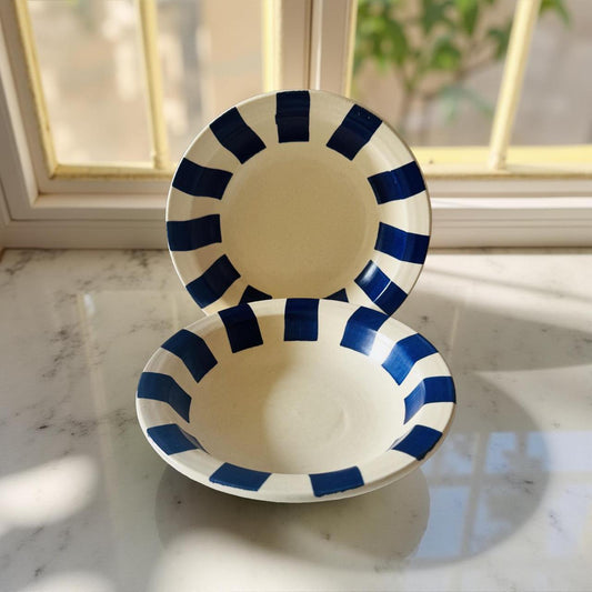 White bowl with blue stripes on a marble surface