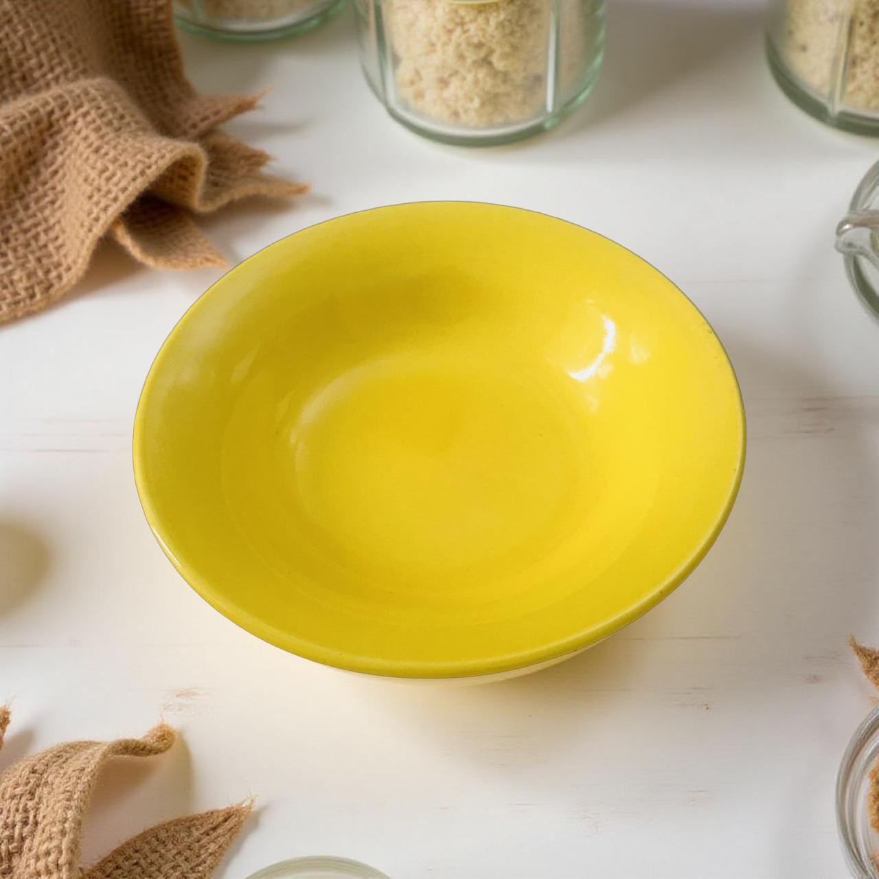 Yellow bowl on a white surface with jars in the background