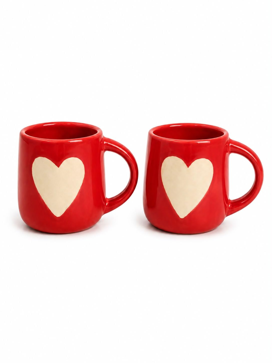 Two red ceramic mugs with a large cream-colored heart on the front, displayed side-by-side on a white background.
