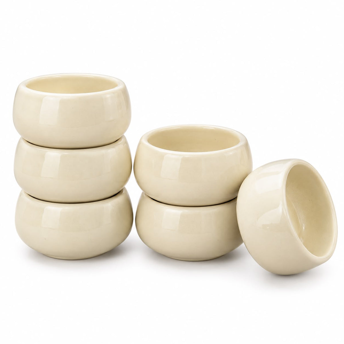 Cream yellow ceramic dessert bowls arranged on a beige countertop, showcasing their rounded silhouette and soft pastel finish for contemporary tableware.