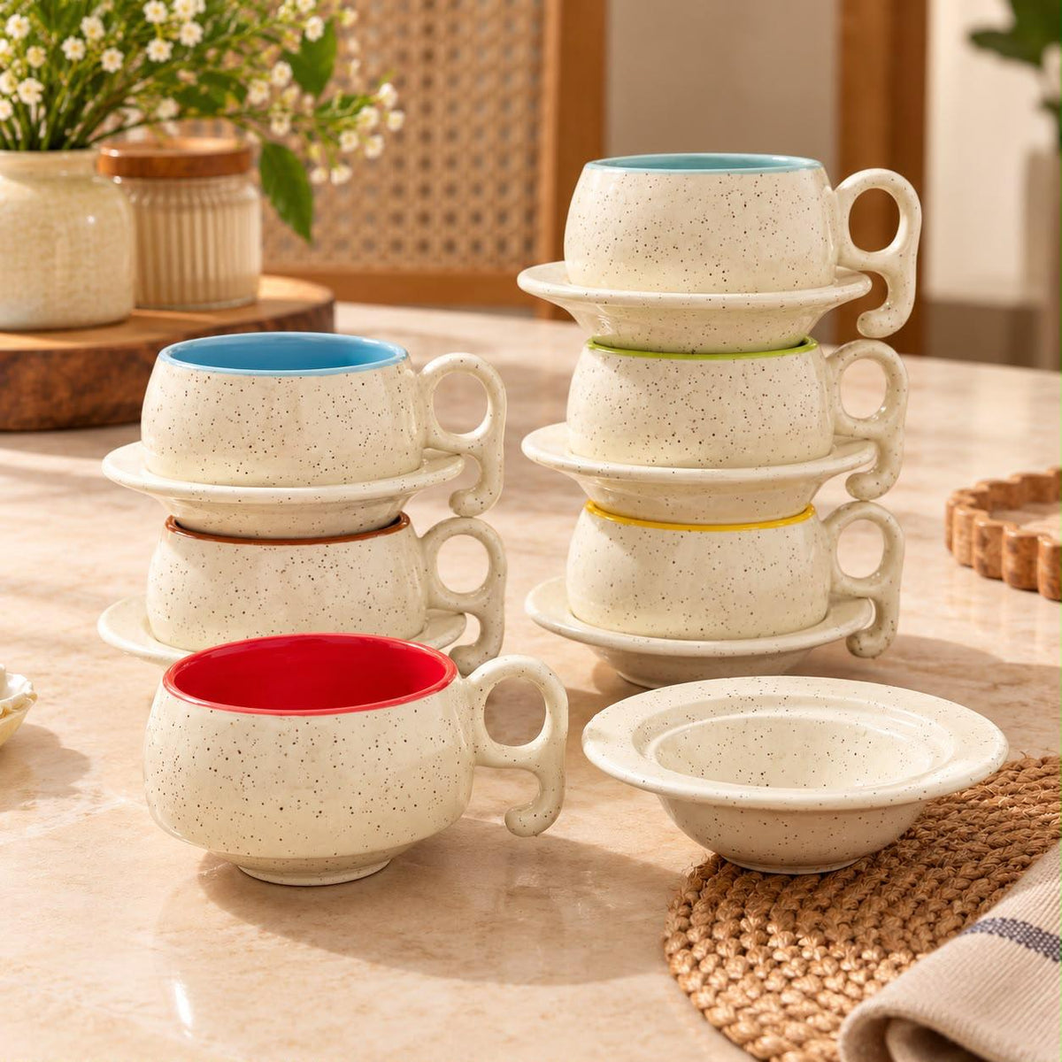 Multicolour ceramic tea cups with contrasting glazed interiors, rounded handles and coordinated saucers by Lupaava.