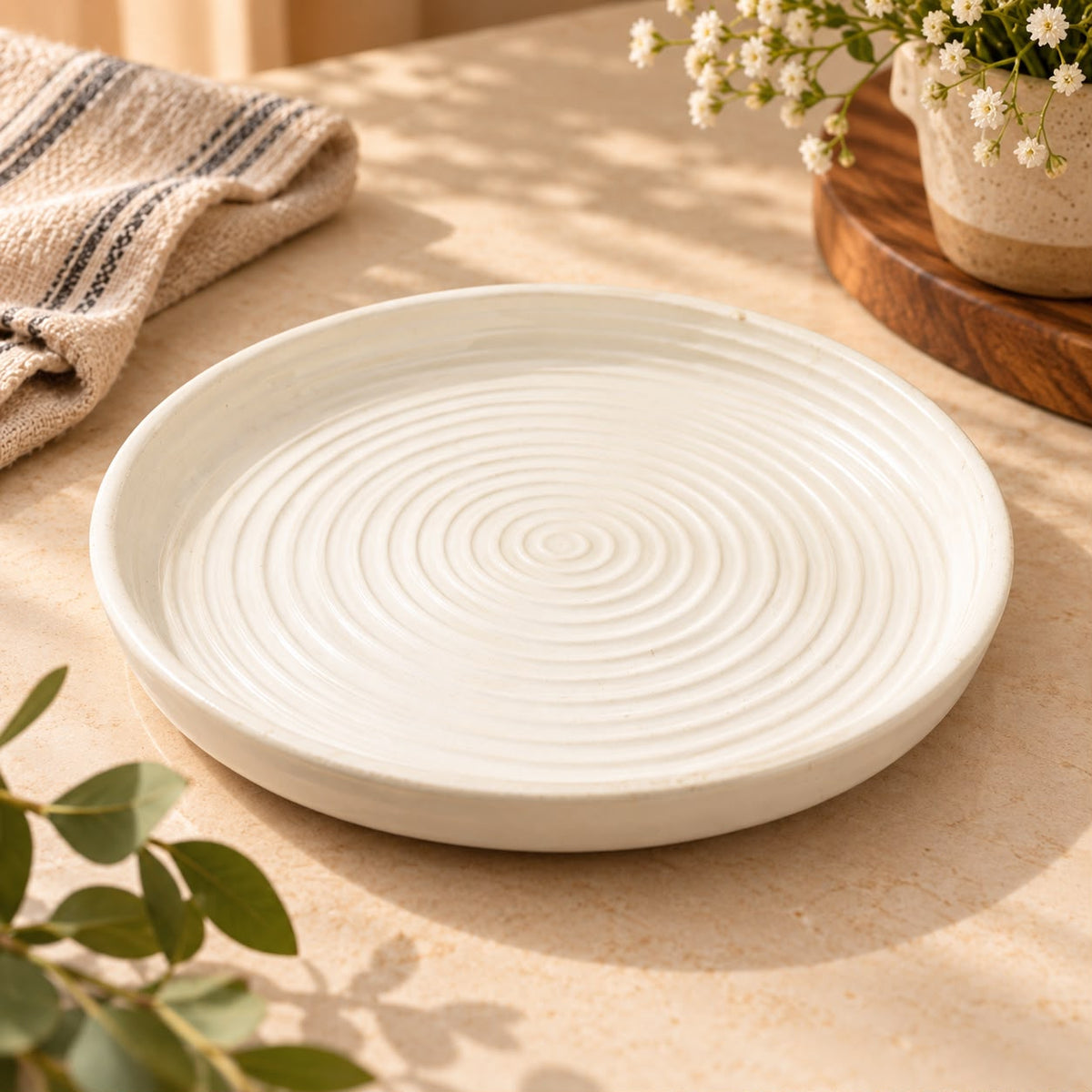 Cream ceramic serving plate for cheese, dry fruits and appetisers on a neutral tabletop.