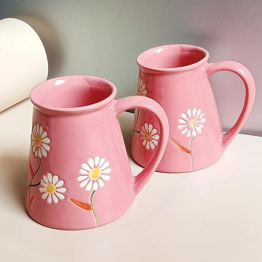 Two pink mugs with floral designs on a light background