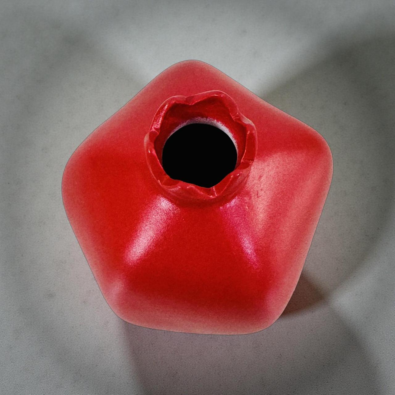 Red planter with a central hole on a gray background