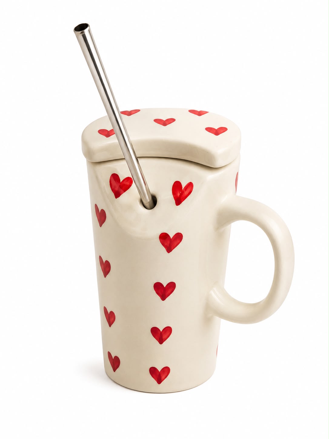 An off-white ceramic mug with a lid, decorated with small red hearts, featuring a stainless steel metal straw.