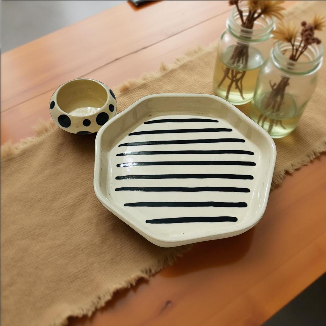 ceramic plate with geomatric shape and design with sauce bowl are placed on a jute table runner