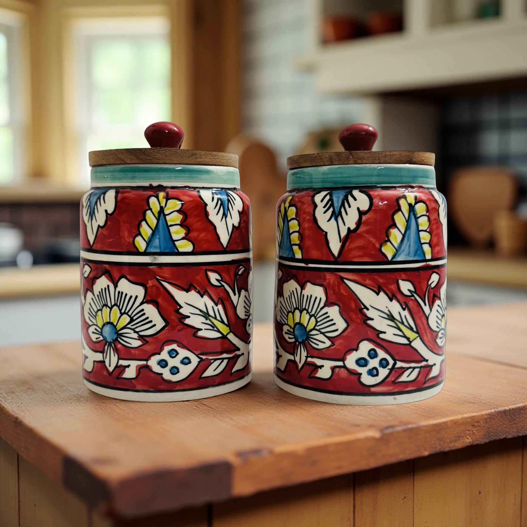 Two ceramic jars with floral patterns on a wooden surface in a kitchen setting.