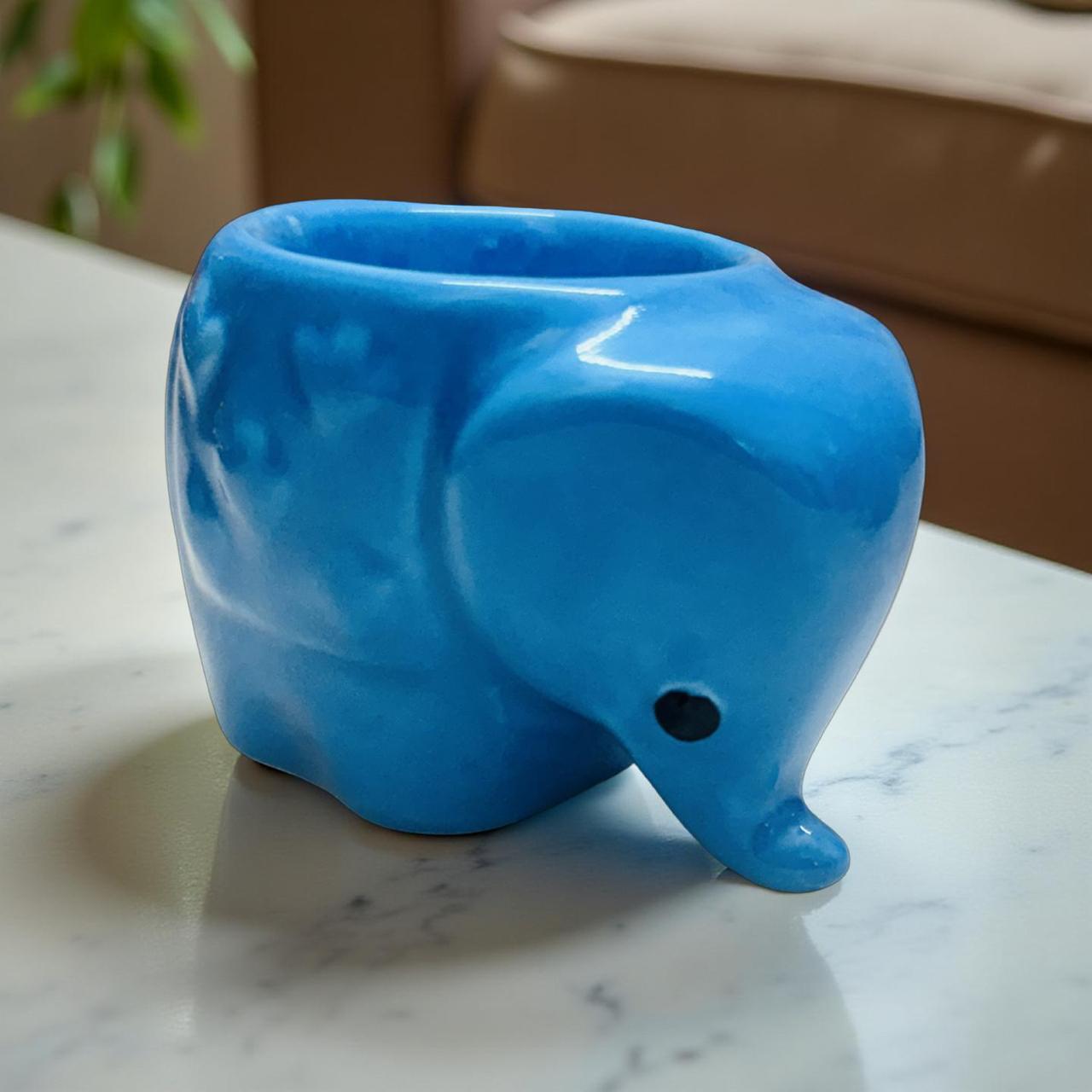 Blue elephant-shaped planter on a marble surface