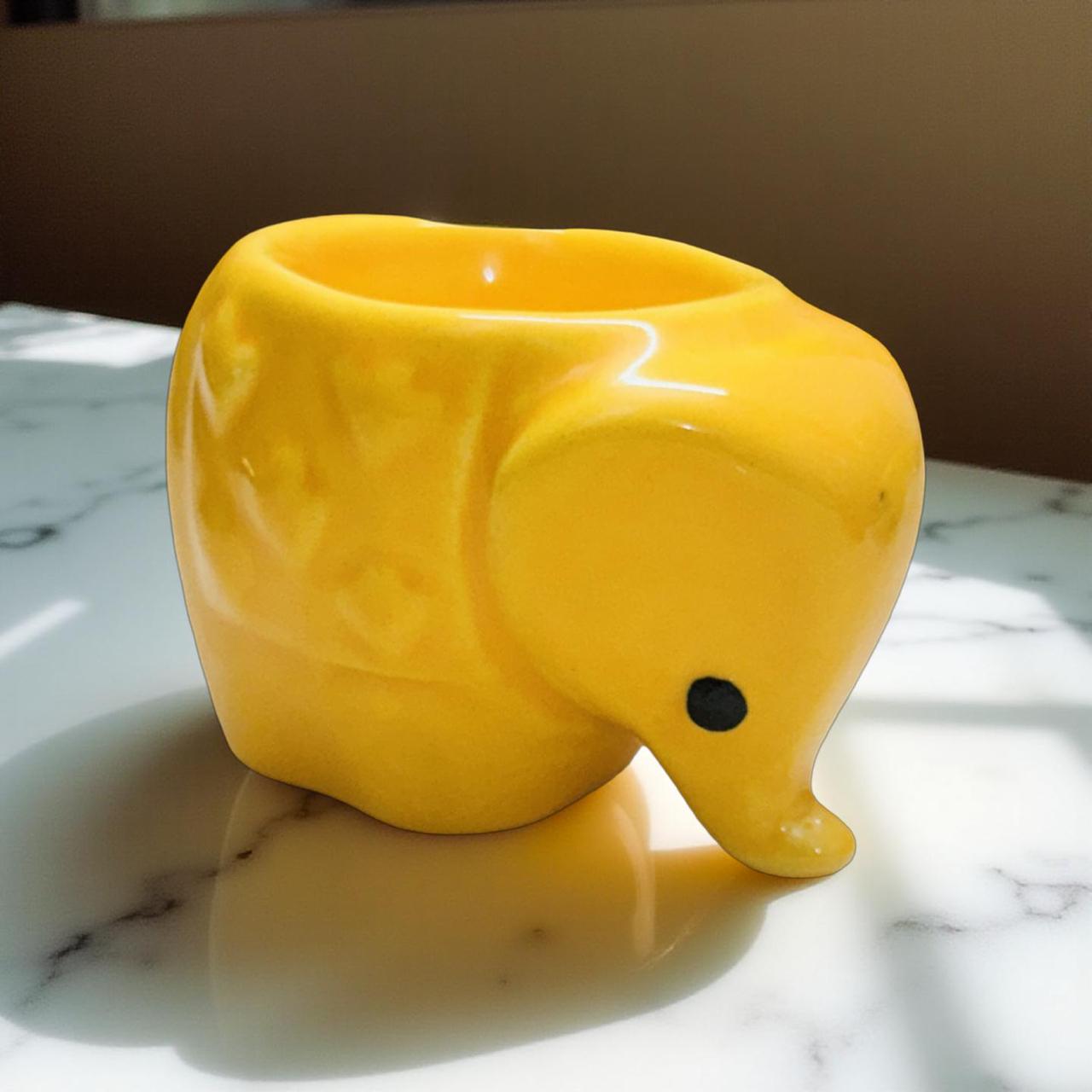 Yellow elephant-shaped planter on a marble surface
