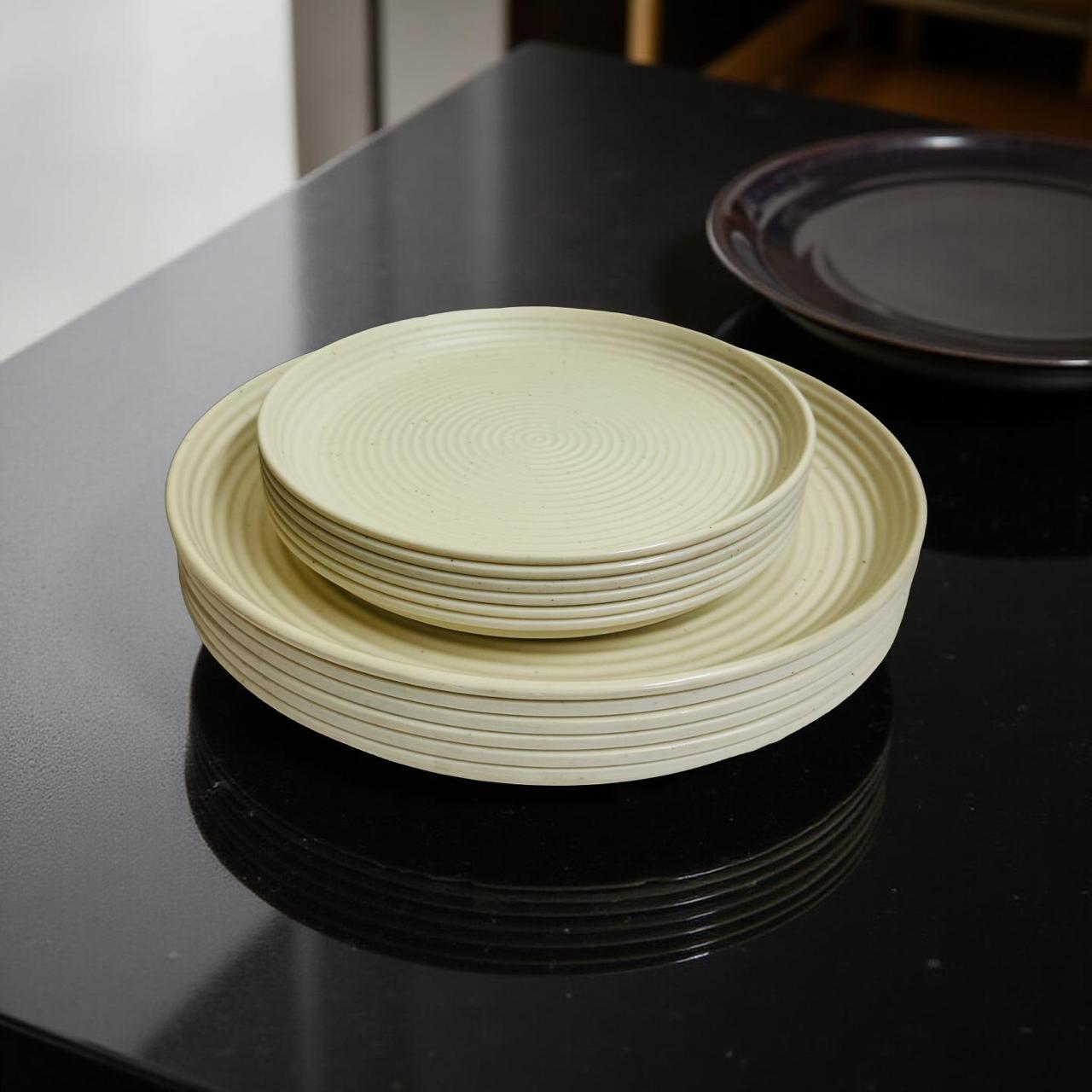 Stack of light beige melamine plates on a black surface