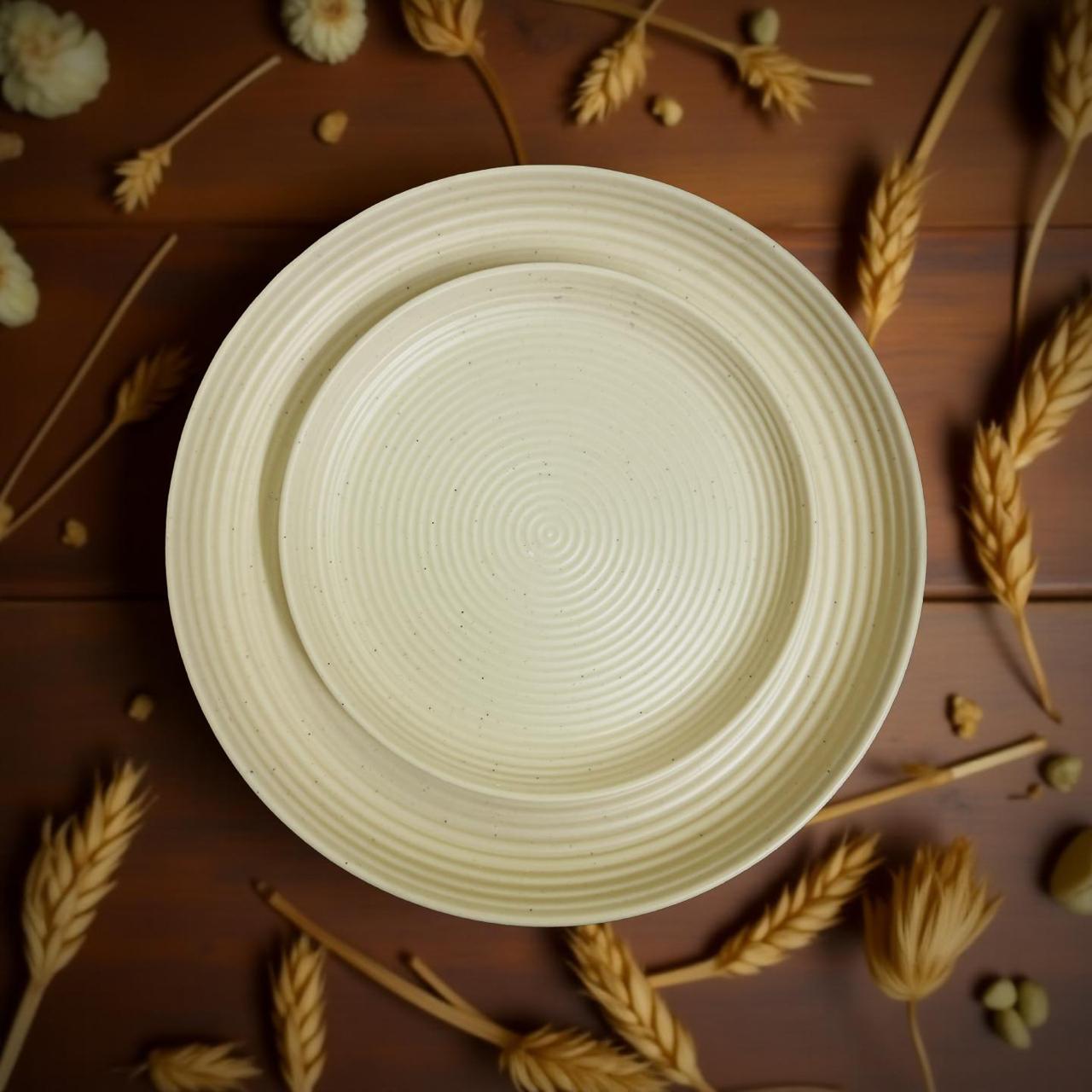 Beige melmine plate on a wooden surface with wheat stalks and flowers.