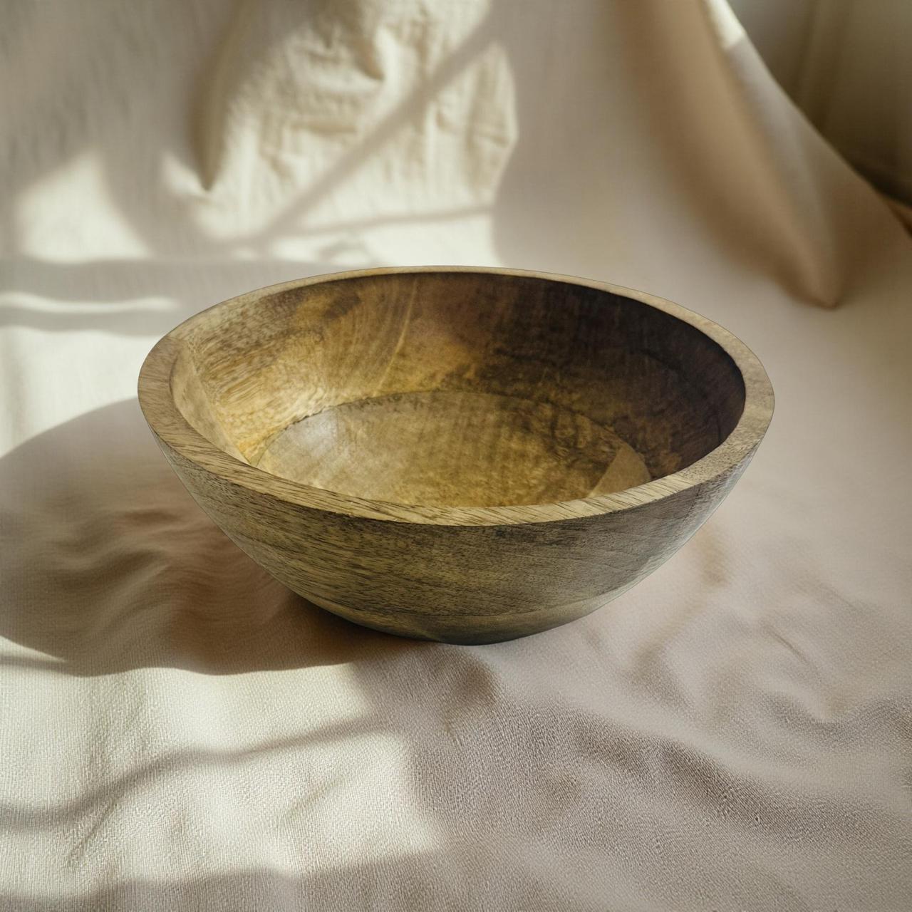 Wooden bowl on a textured beige surface