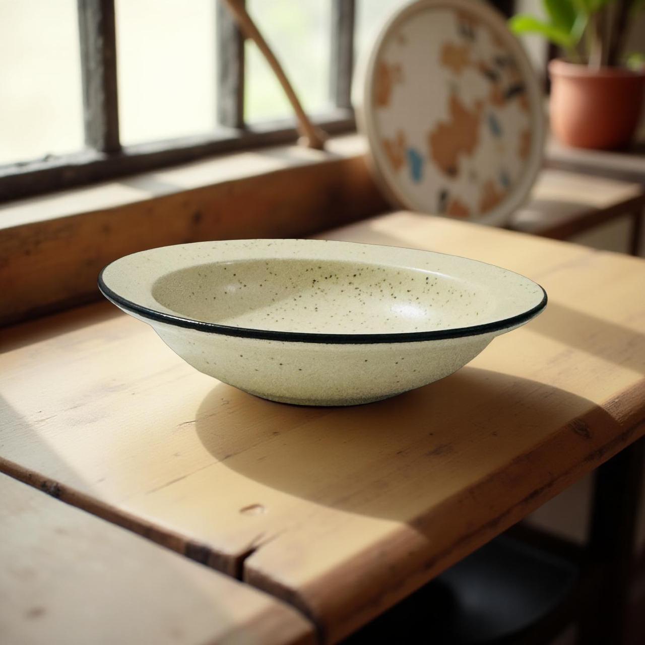 Speckled ceramic bowl on a wooden surface with natural light