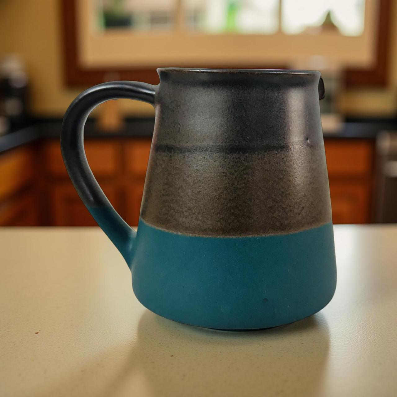 Blue and black ceramic pitcher on a kitchen counter