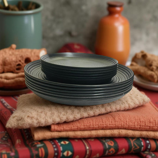 Stack of black melamine plates on a colorful fabric background