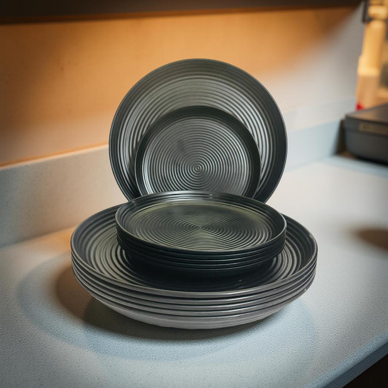 Set of black melamine plates with spiral design on a light surface