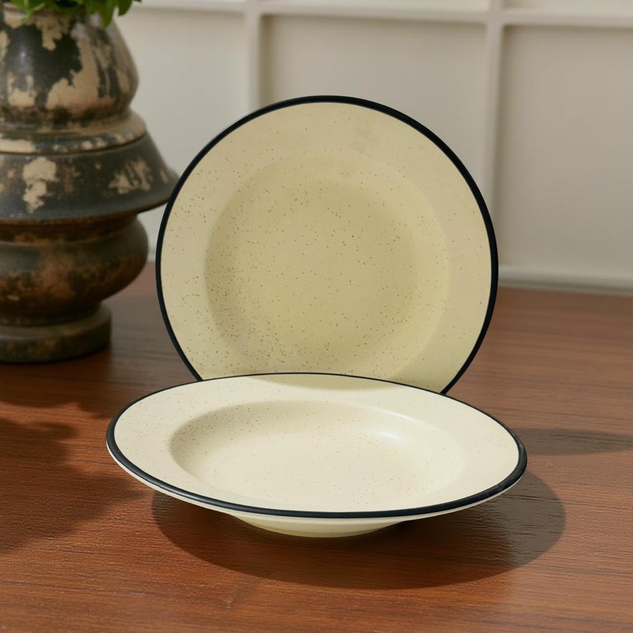 Two ceramic bowls with black rims on a wooden surface.