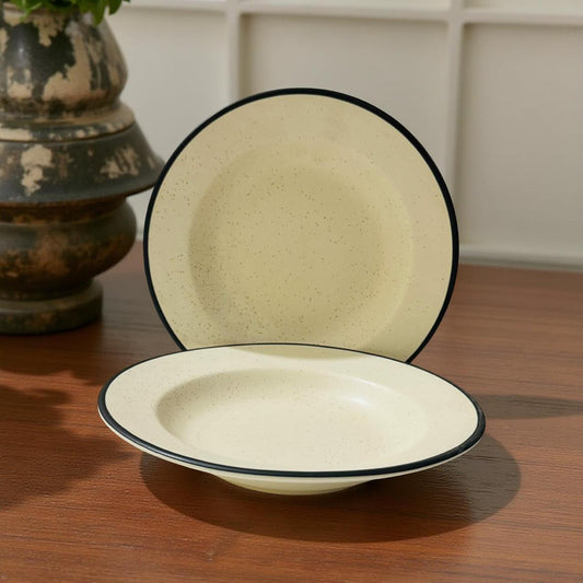 Two ceramic bowls with black rims on a wooden surface.