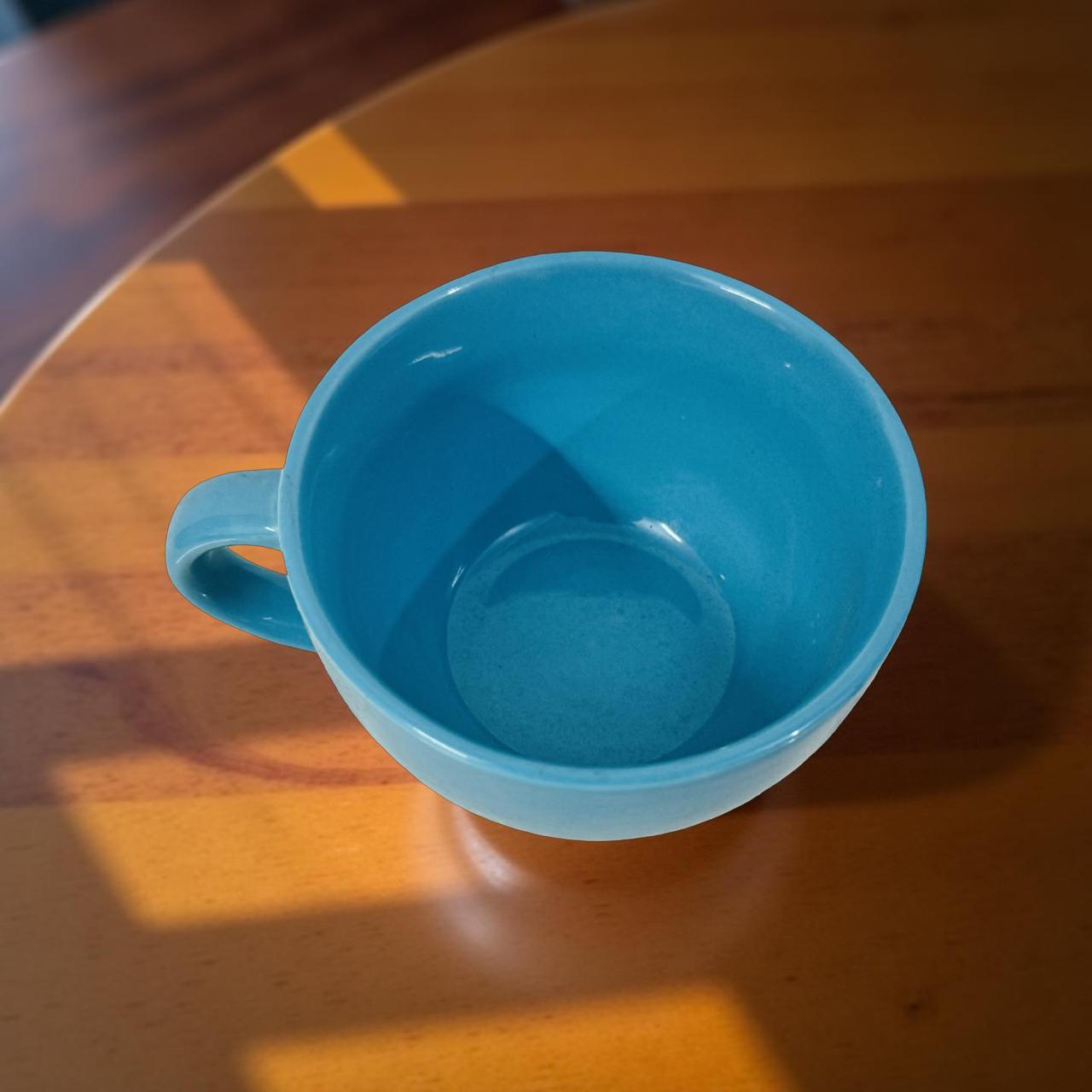 blue big size ceramic coffee muh placed on a sunny wooden surface