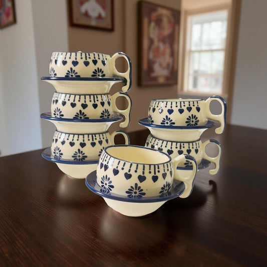 Set of ceramic cups with saucers on a wooden table