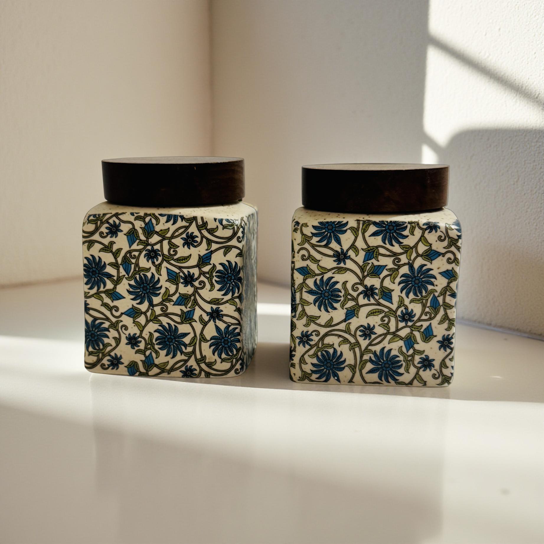 Two decorative jars with floral patterns on a light surface.