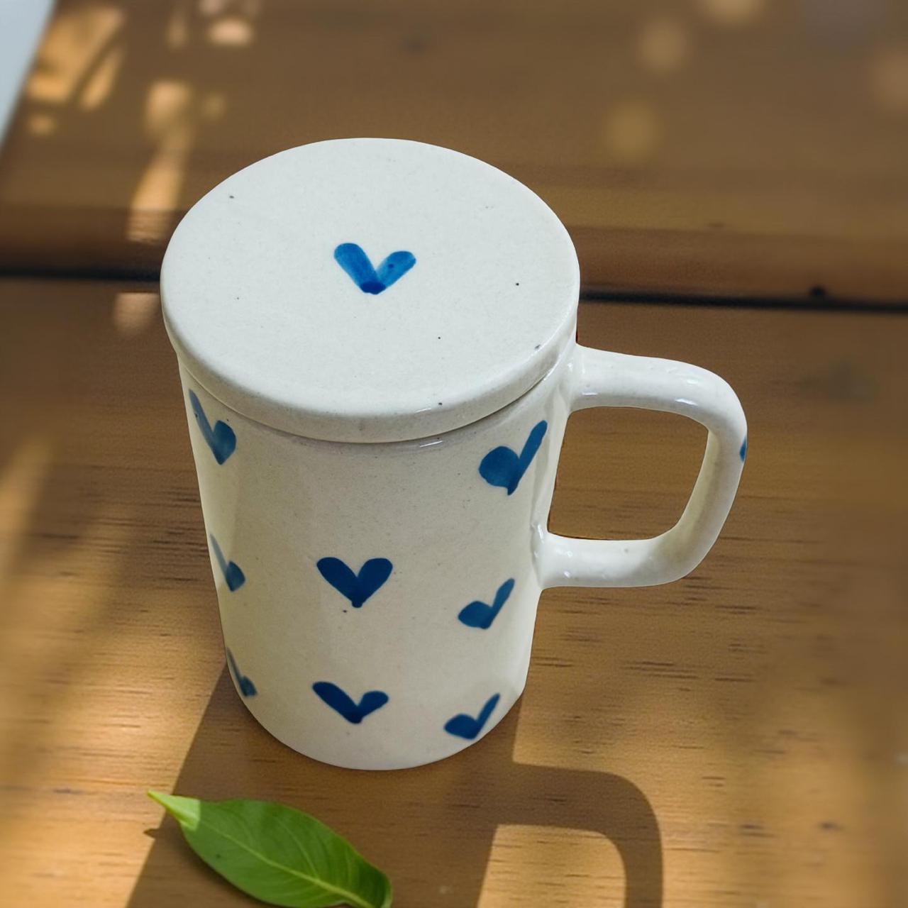 White mug with blue heart patterns on a wooden surface