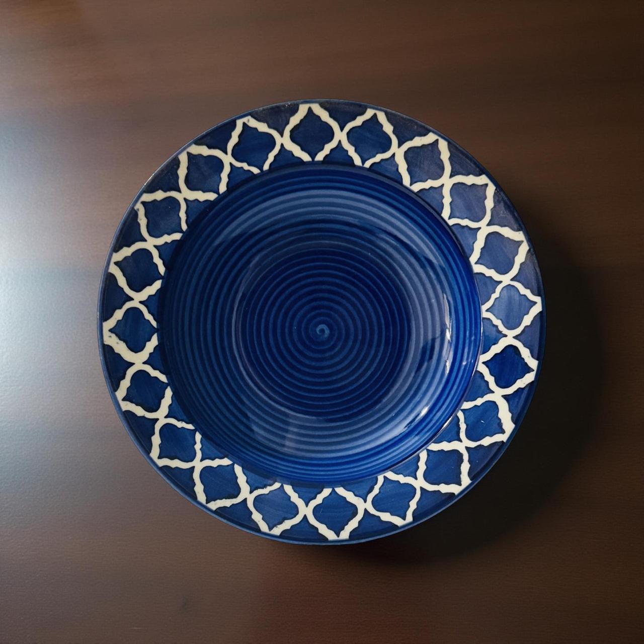 Blue ceramic plate with white geometric pattern on a wooden surface