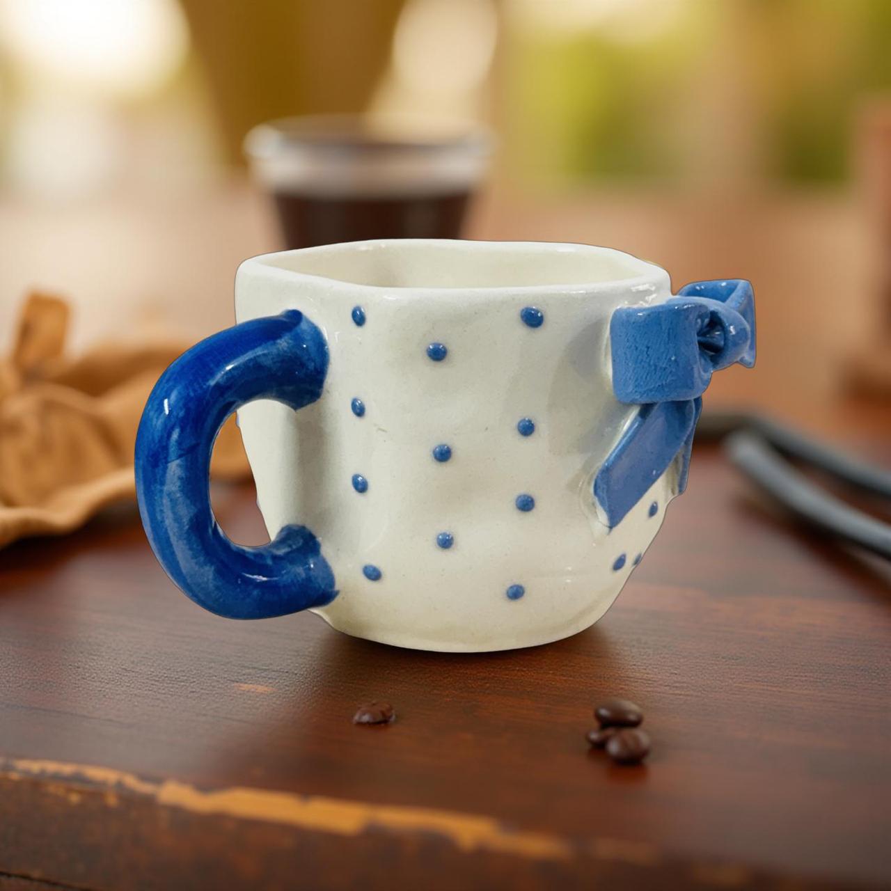 Ceramic mug with sculpted blue ribbon design on wooden table