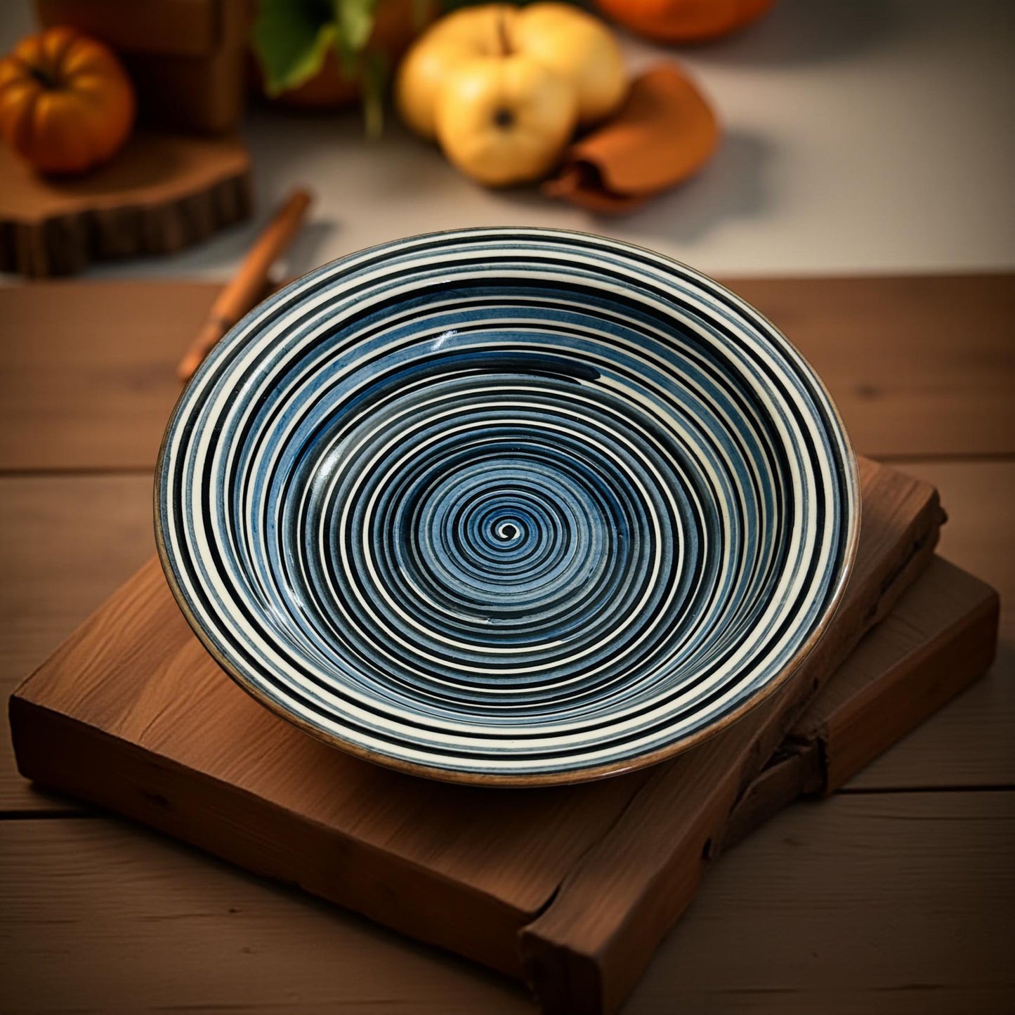 Decorative blue and white striped plate on a wooden surface with pumpkins in the background