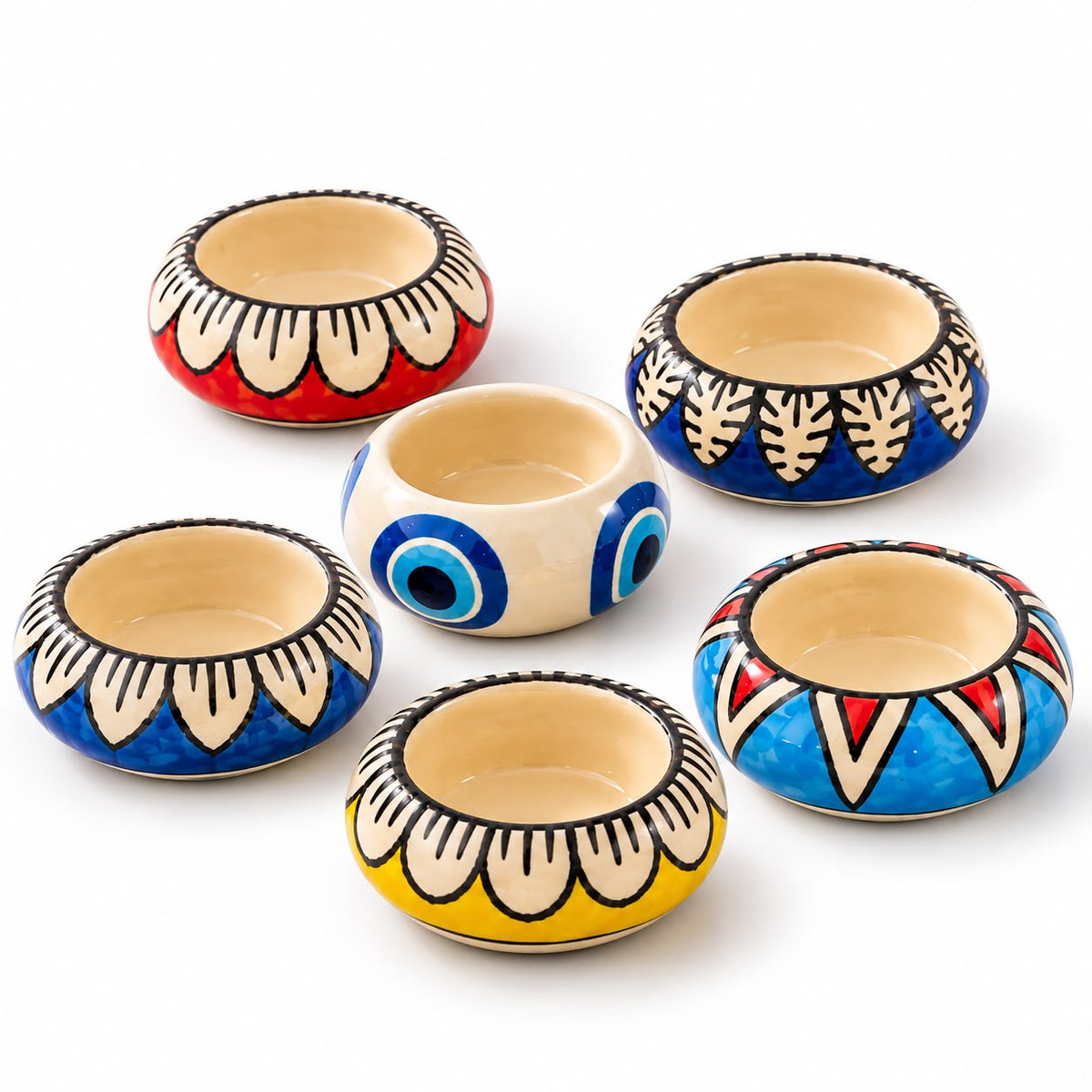 Multicolour ceramic candle holders with folk-inspired patterns and blue evil-eye designs