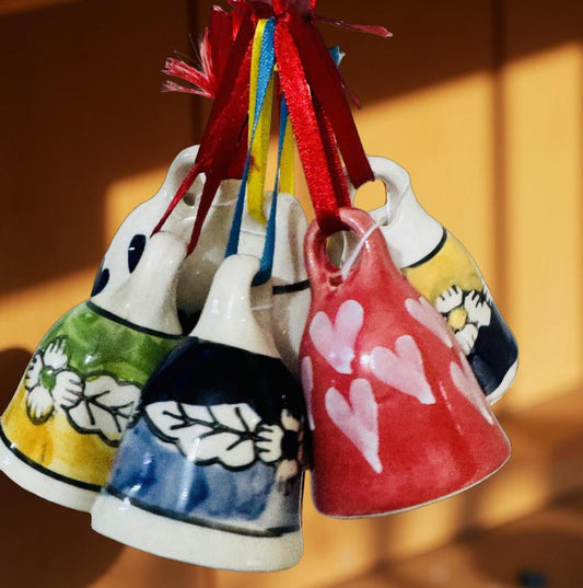 Colorful ceramic bells with decorative designs on a wooden surface