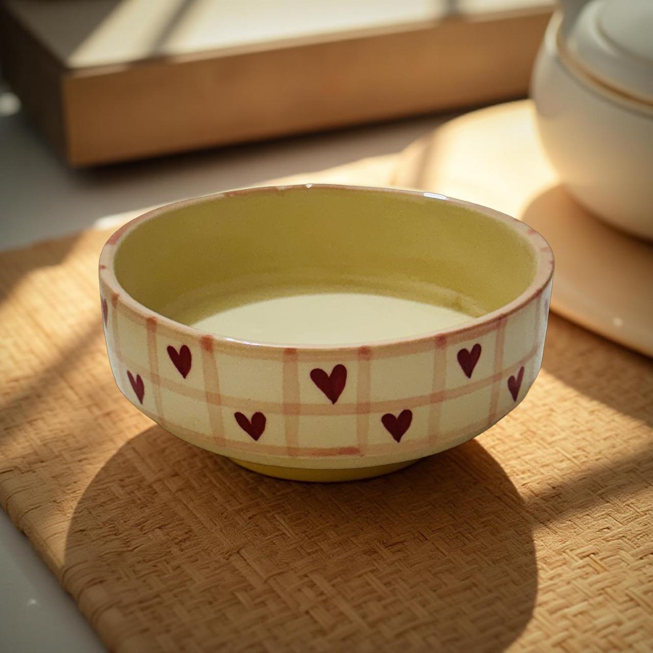 Ceramic bowl with heart patterns on a wooden surface