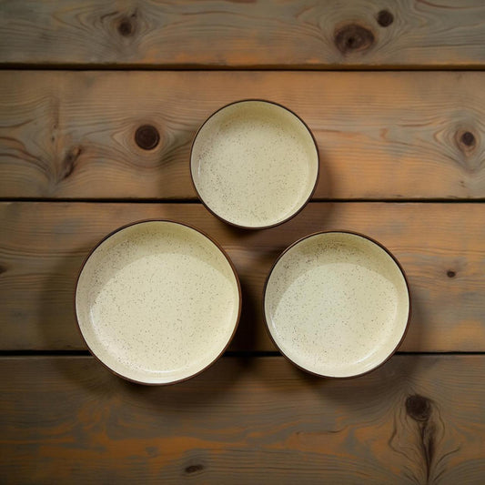 three ceramic bowls with brown rim placed on a wooden surface