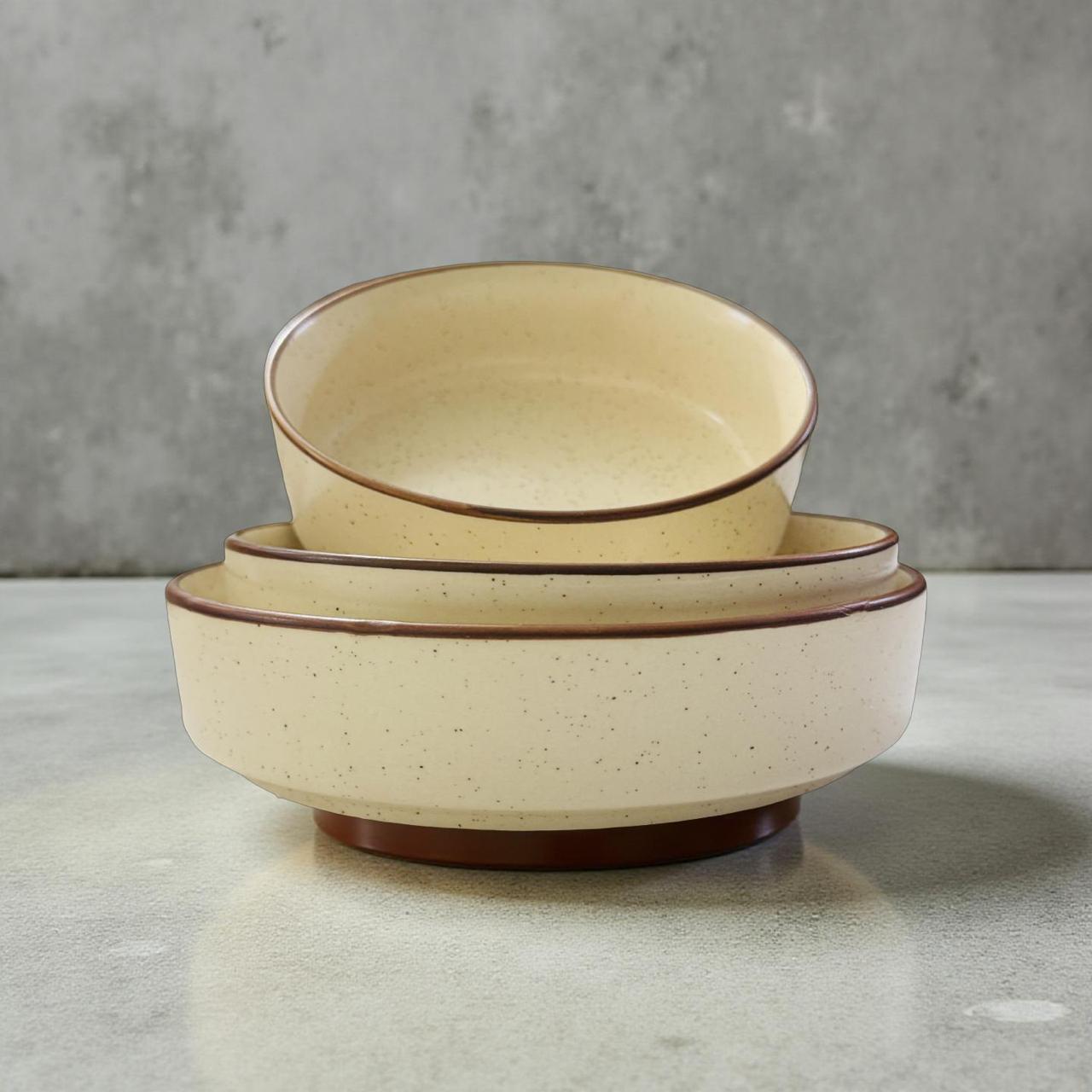 three stackable ceramic bowls placed inside each other on a brown rim 