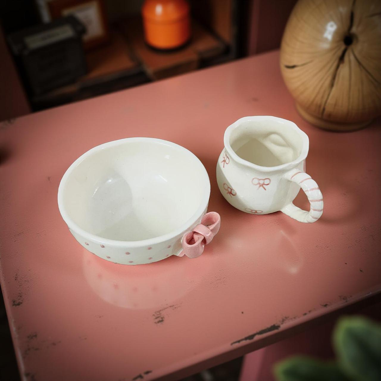 Two ceramic bowls on a pink surface with a blurred background