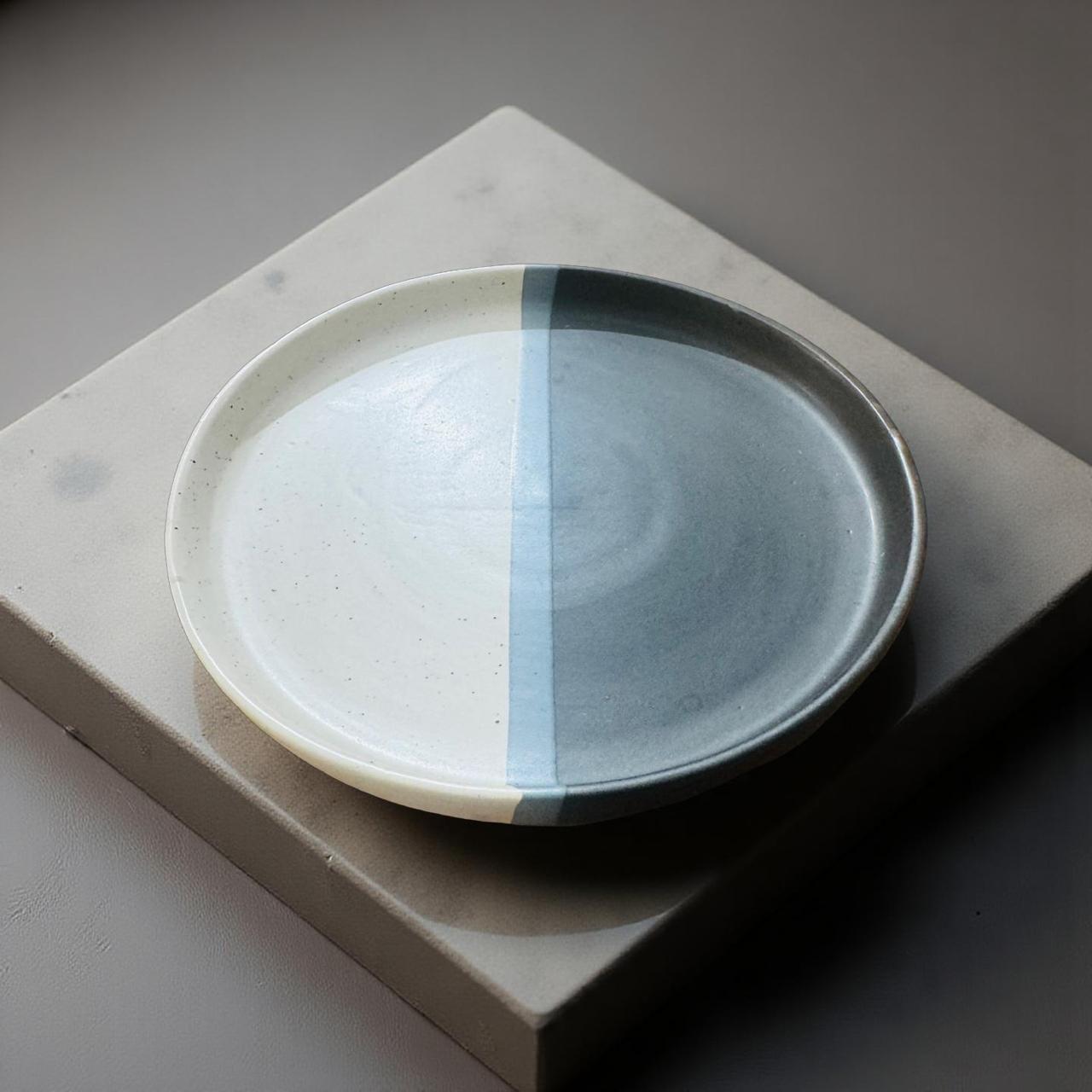 Ceramic plate with two-tone design on a gray surface