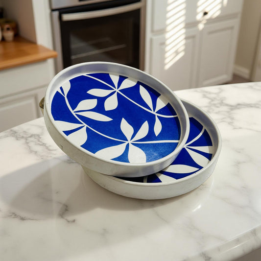 Set of two blue and white floral ceramic flat plates on marble kitchen counter