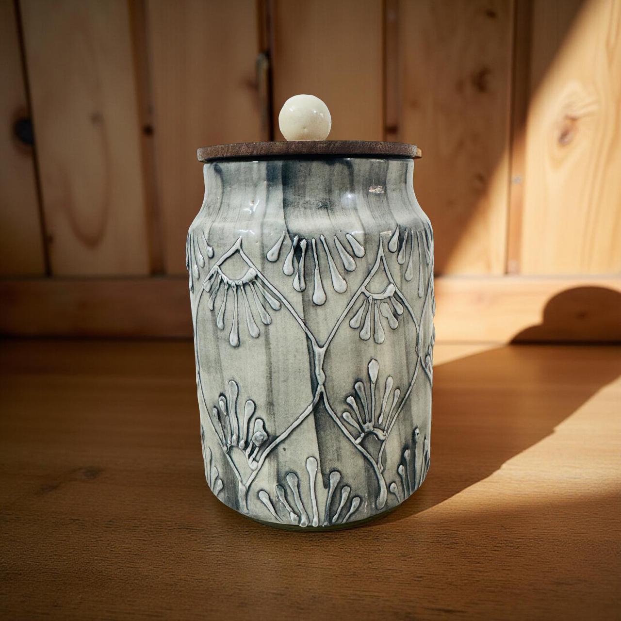 Ceramic jar with decorative patterns on a wooden surface