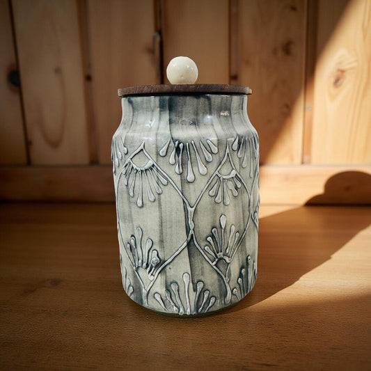 Ceramic jar with decorative patterns on a wooden surface