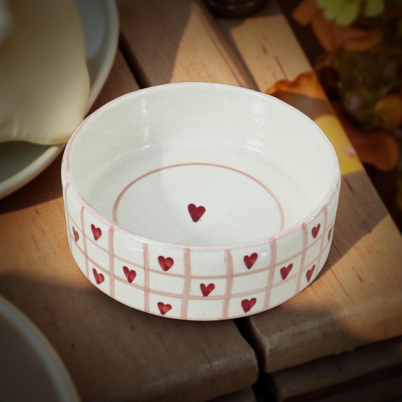 handpainted ceramic red heart bowl kept on a wooden surface 