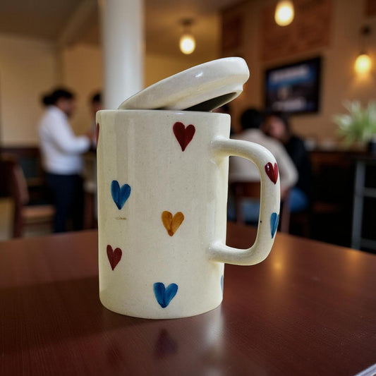 White mug with colorful heart designs on a wooden table in a blurred indoor setting