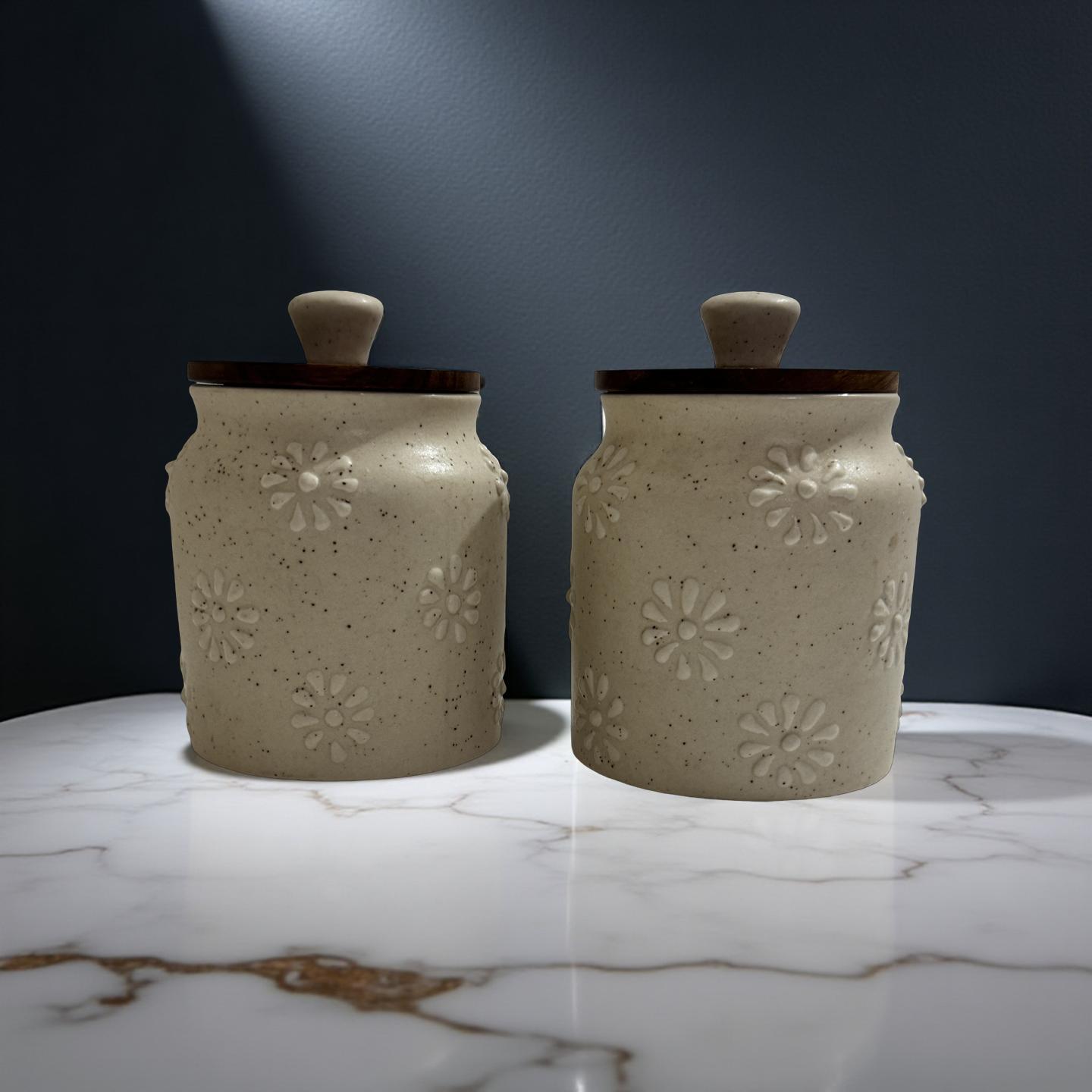 Two ceramic jars with floral patterns on a marble surface