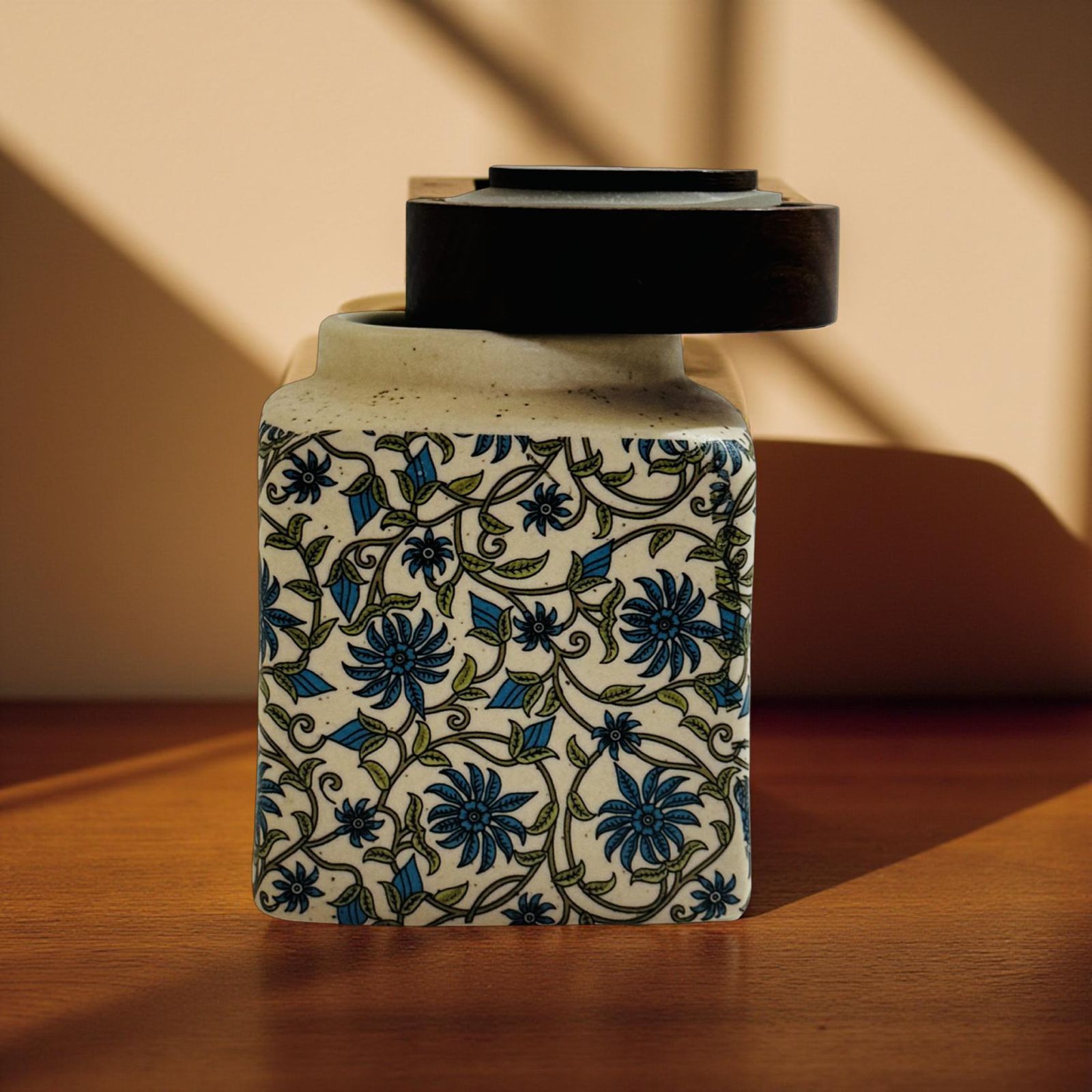 Decorative ceramic jar with floral patterns on a wooden surface