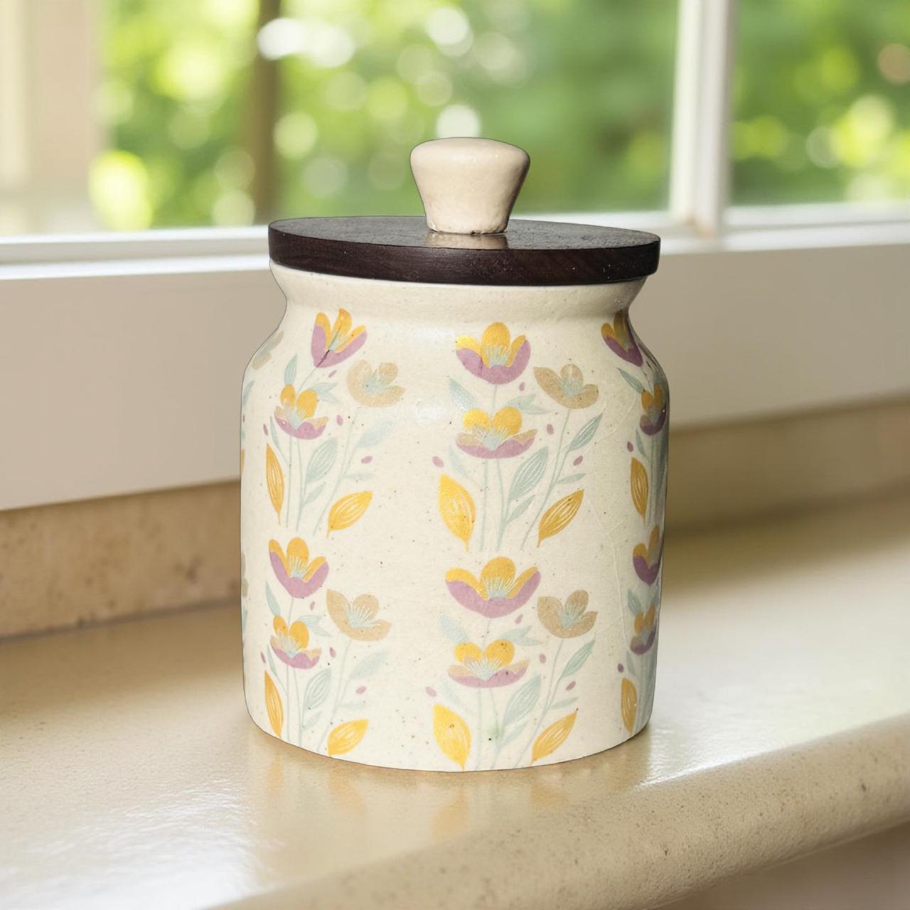 Ceramic jar with floral pattern and wooden lid on a windowsill